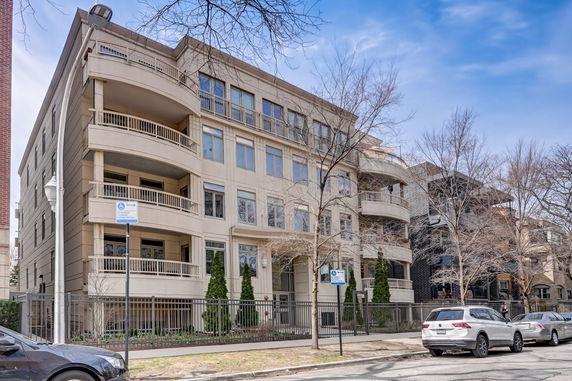 Front view of a multi-story residential building with balconies and large windows.