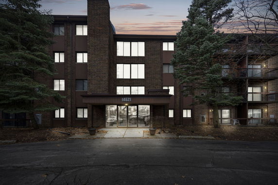 Front view of a multi-story brick apartment building with a central entrance.