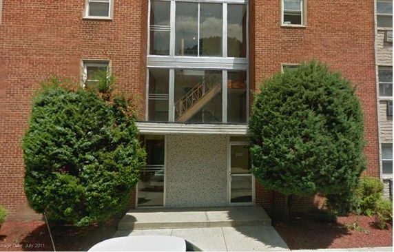 Front view of a multi-story brick building with a central glass entrance.