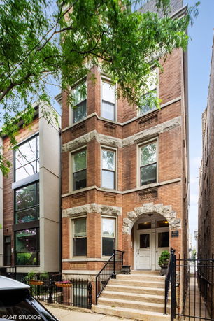 Front view of a multi-story brick building with decorative stone accents.