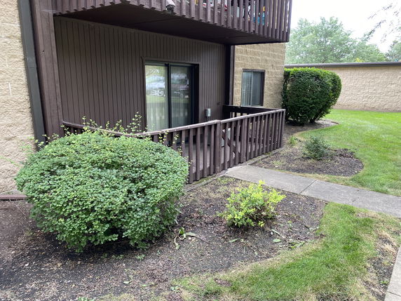 Front view of a building with a wooden railing and sliding glass door.
