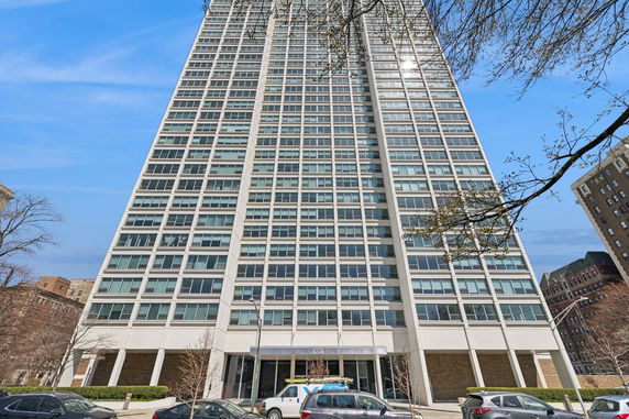 Front view of a high-rise building with multiple windows and a white facade.