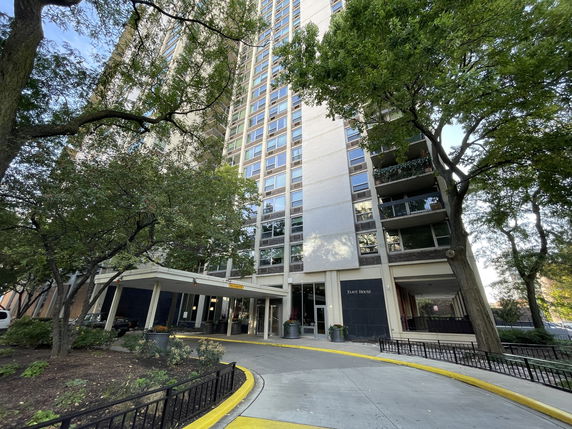 Front view of a high-rise residential building with an entrance canopy.
