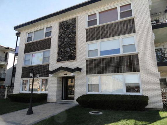 Front view of a three-story apartment building with distinct brick facade.