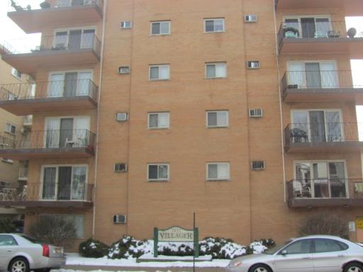 Front view of a multi-story apartment building with balconies.