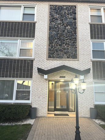 Front view of a multi-story building with stone and brick exterior.