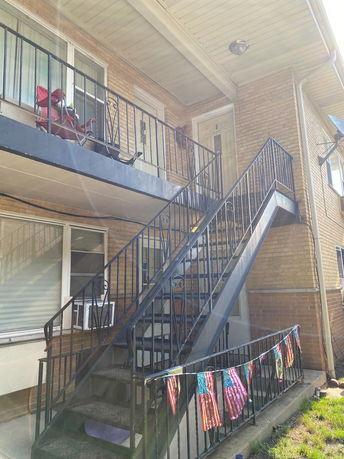 Front view of a two-story building with external staircase.
