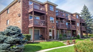 Front view of a multi-story brick building with balconies.