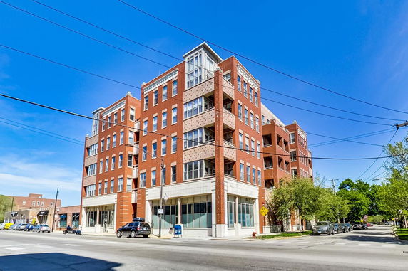 Front view of a multi-story brick building on a corner lot.