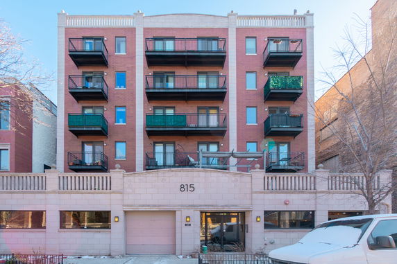 Front view of a multi-story apartment building with balconies.