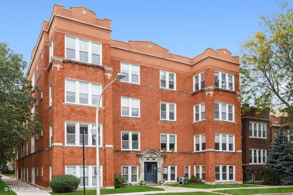 Front view of a multi-story brick apartment building.