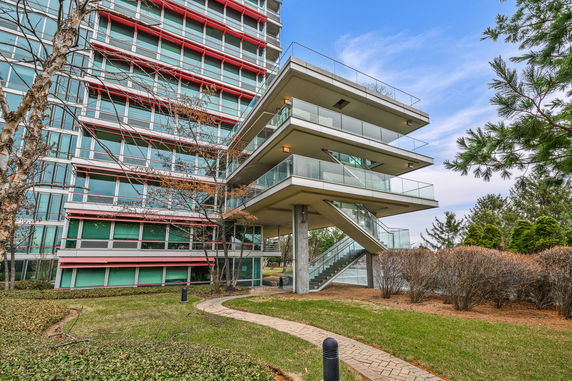 Front view of a multi-story building with a modern facade and balconies.
