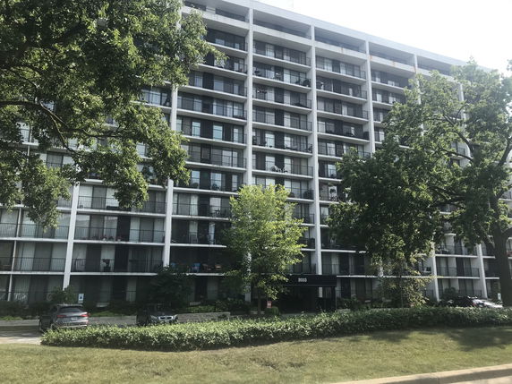 Front view of a multi-story residential building with balconies.