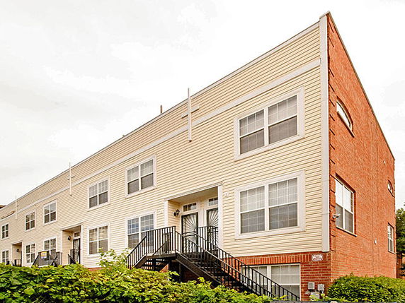 Front view of a multi-story building with a brick and siding exterior.