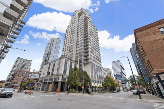 Front view of a high-rise building at a city intersection.
