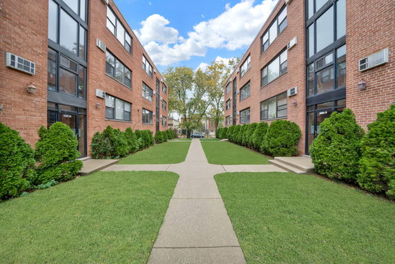 Front view of a multi-story brick apartment building.