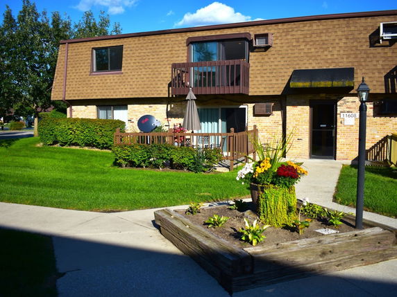Front view of a two-story building with brick and shingle exterior.