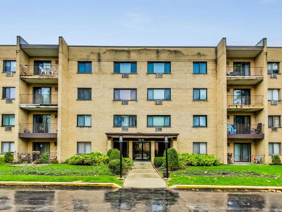 Front view of a multi-story apartment building with balconies.