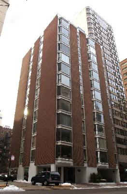 Front view of a multi-story brick building with large windows.