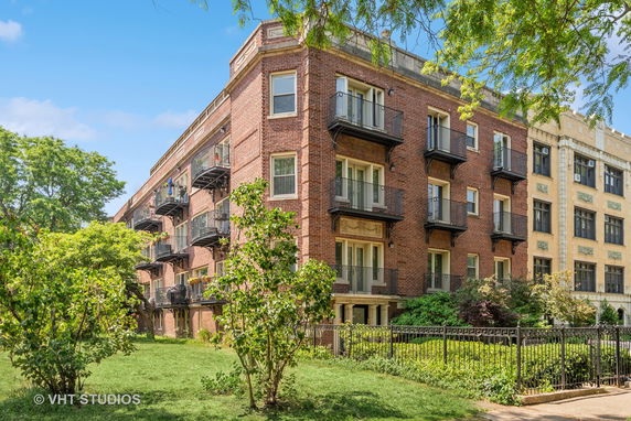 Front view of a brick apartment building with balconies.