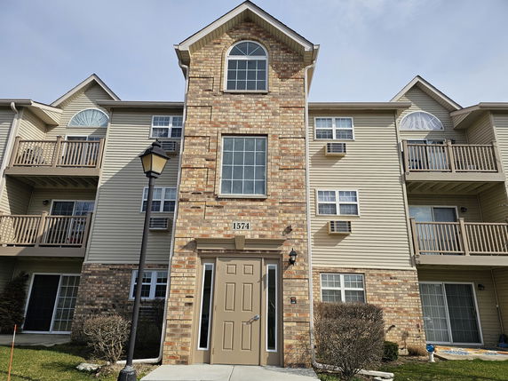 Front view of a multi-story apartment building with balconies.
