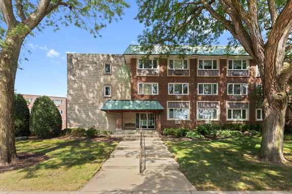 Front view of a three-story brick residential building with multiple windows and a central entrance.
