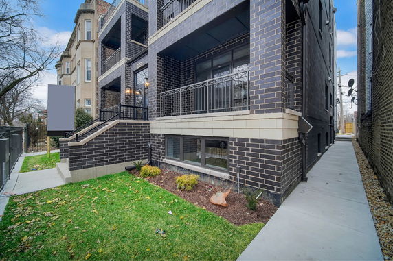 Front view of a multi-story building with brick facade and balconies.