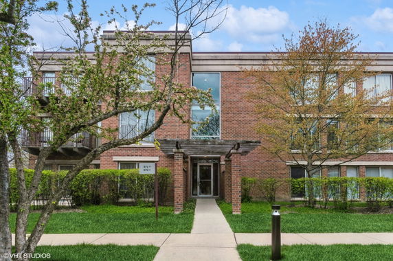 Front view of a two-story brick building with entrance and windows.