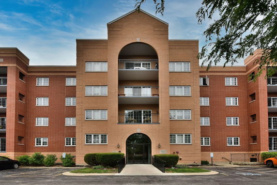 Front view of a multi-story apartment building with balconies.