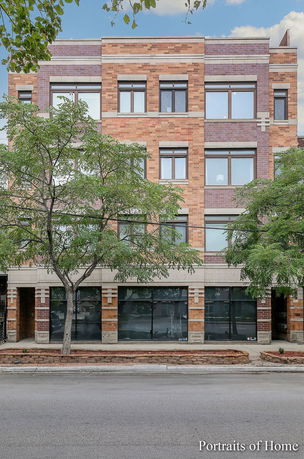 Front view of a multi-story building with brick facade and large windows.