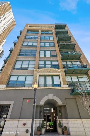 Front view of a multi-story brick building with balconies.