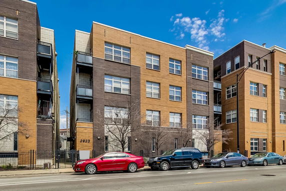 Front view of a mid-rise apartment building with large windows and multiple floors.