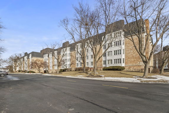 Front view of a multi-story apartment building with a brick exterior and numerous windows.