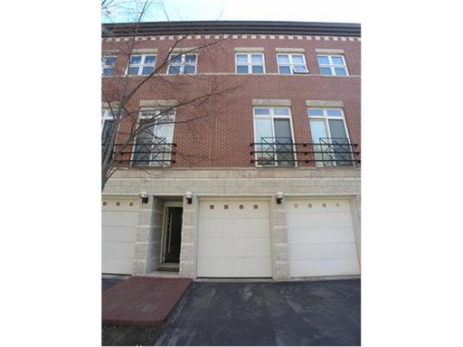 Front view of a multi-story brick building with garage doors.