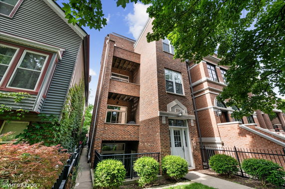 Front view of a multi-story brick building with balconies.