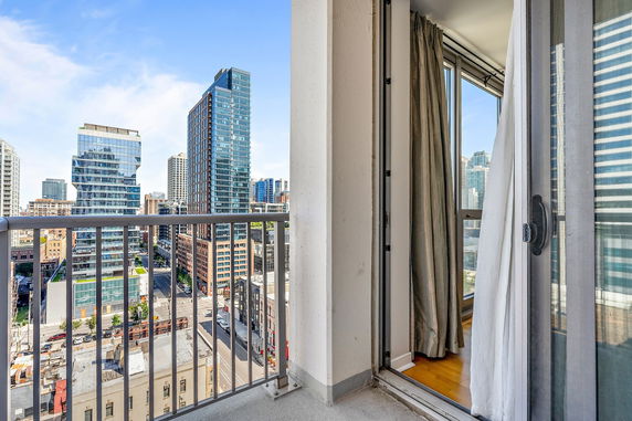 View from a balcony overlooking a cityscape with high-rise buildings.