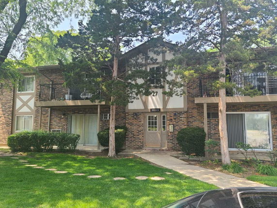 Front view of a two-story brick building with balconies.