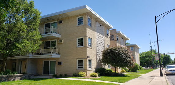 Front view of a three-story apartment building with balconies.