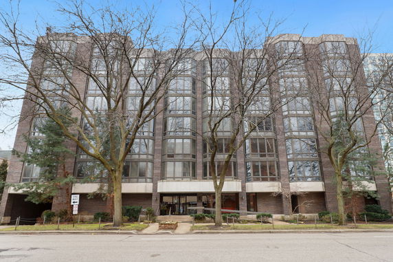Front view of a multi-story building with large windows and a brick facade.