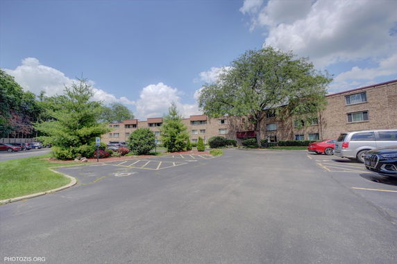 Front view of a multi-story apartment building with brick facade.