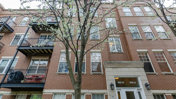 Front view of a multi-story brick building with balconies and a main entrance.