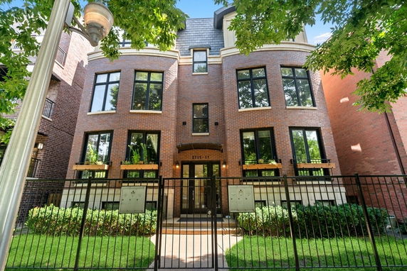 Front view of a multi-story brick building with large windows.