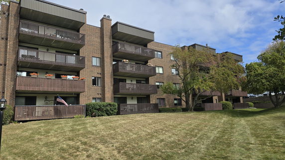 Front view of a multi-story apartment building with balconies.
