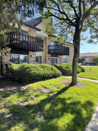 Front view of a two-story building with balconies and brick exterior.