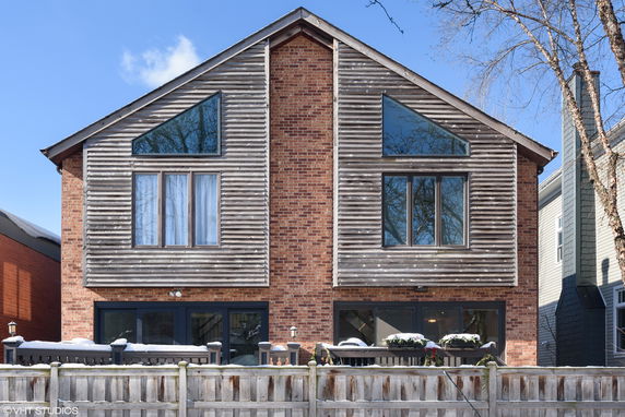 Front view of a two-story house with brick and wood siding.
