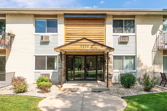 Front view of a two-story apartment building with a brick and siding exterior.