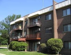 Front view of a multi-story apartment building with balconies.