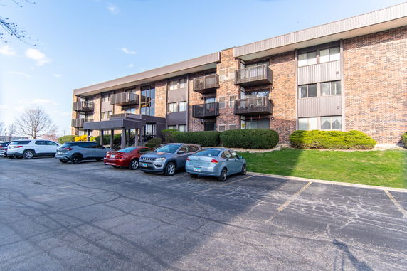 Front view of a multi-story apartment building with balconies.
