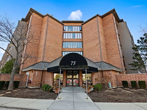 Front view of a multi-story brick building with an entrance canopy.