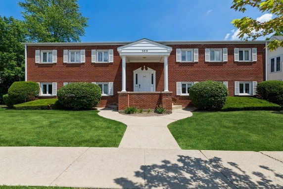 Front view of a two-story brick building with columns at the entrance.